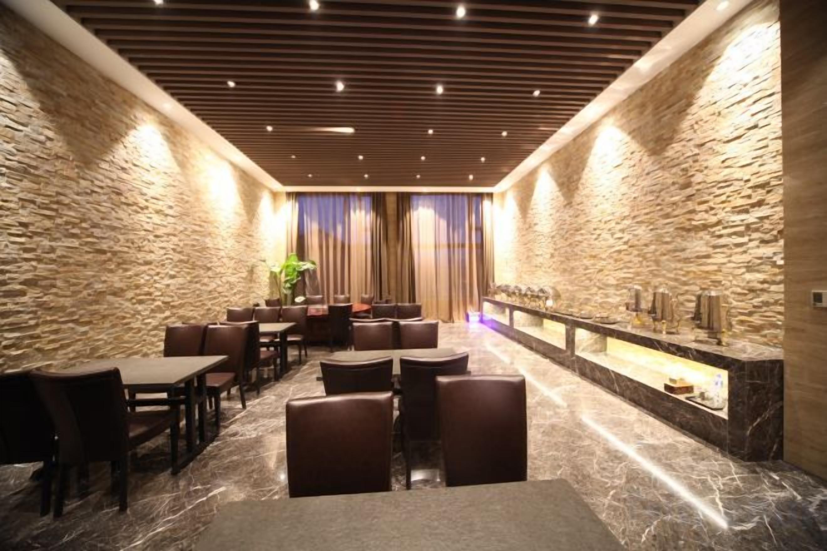A hotel lobby with stone walls, a marble floor, and a reception desk.