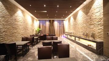 A hotel lobby with stone walls, a marble floor, and a reception desk.