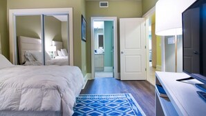 A bedroom with a bed, a TV, a desk, and a wardrobe. - Cozy Three Bedroom Bayside Unit with Gorgeous Bay Views! Complimentary Boat Slip! (Orange Beach)