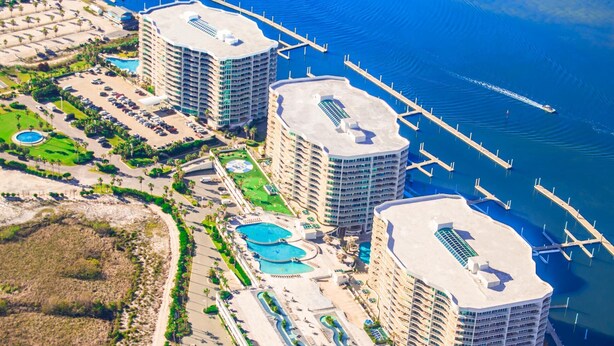 A high-rise hotel with multiple swimming pools, a marina, and a beach area. - Cozy Three Bedroom Bayside Unit with Gorgeous Bay Views! Complimentary Boat Slip! (Orange Beach)