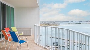 A balcony with a view of the water and distant buildings. - Cozy Three Bedroom Bayside Unit with Gorgeous Bay Views! Complimentary Boat Slip! (Orange Beach)