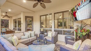A spacious living area with a large sofa, a coffee table, and wicker furniture. - Palm Oasis: Pool, Spa, Putting Green, BBQ! (Indio)