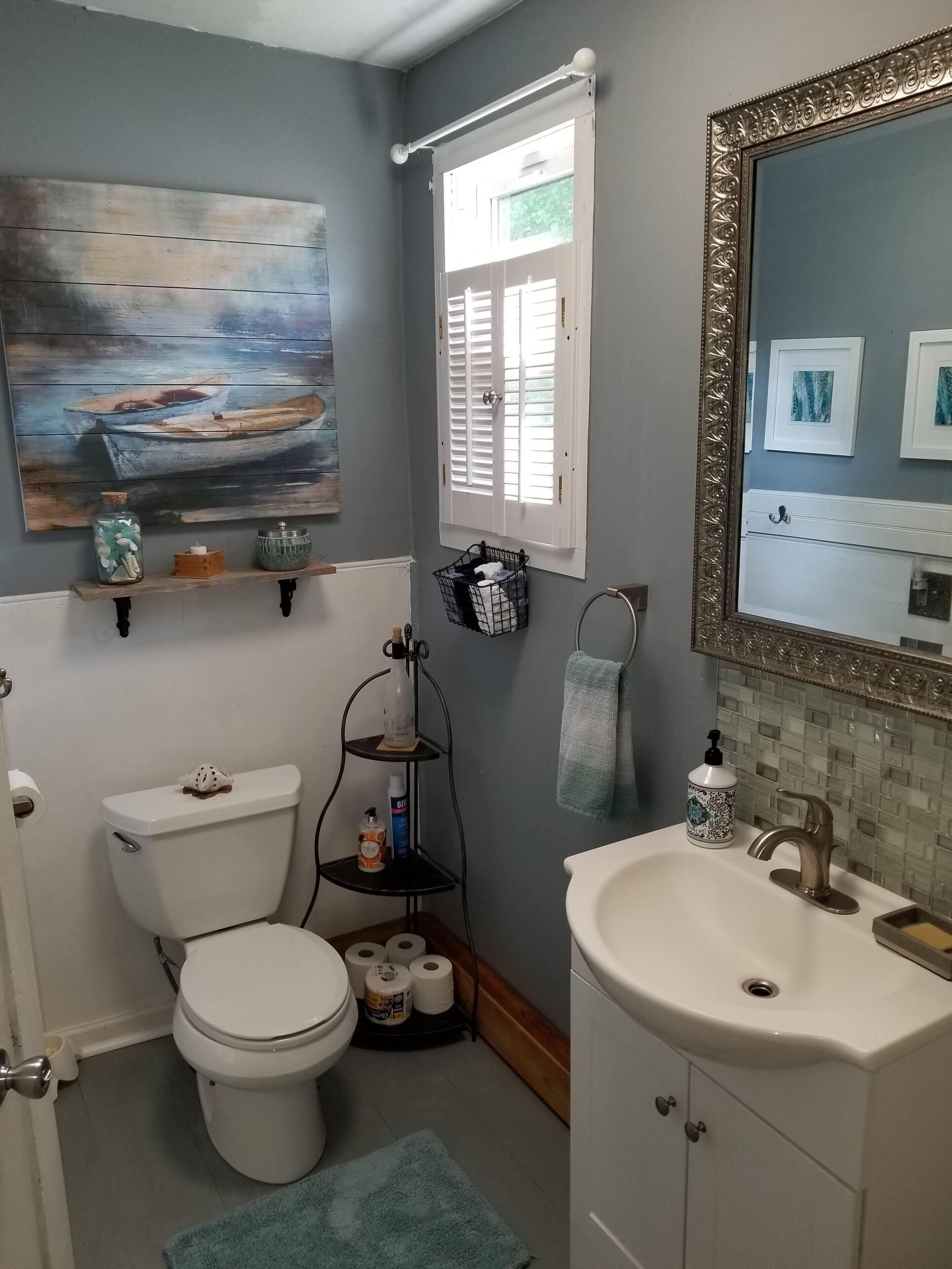 Ein Badezimmer mit Toilette, Waschbecken und einem Regal mit Dekoration.