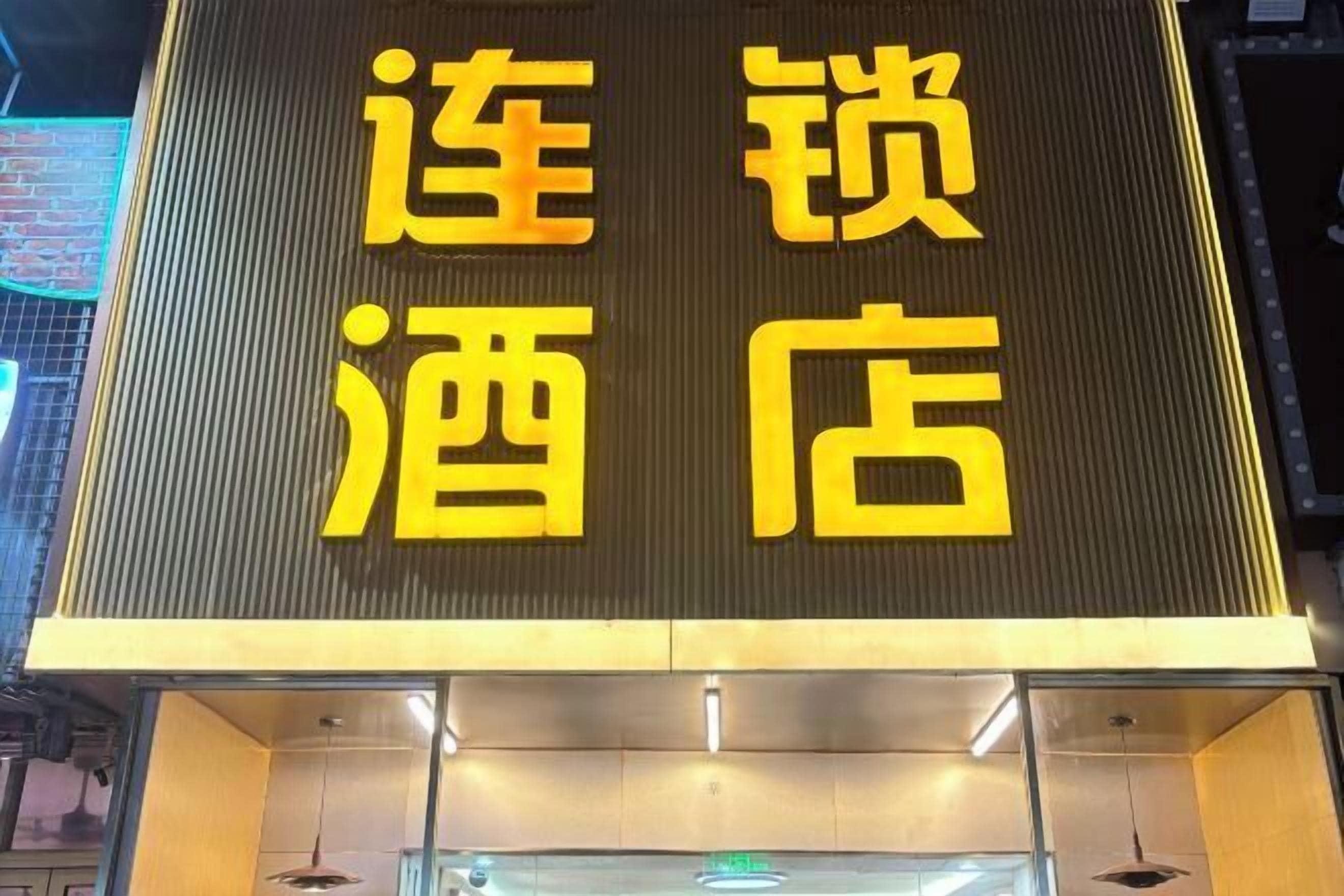 A hotel sign with large yellow characters on a dark background.