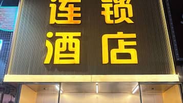 A hotel sign with large yellow characters on a dark background.