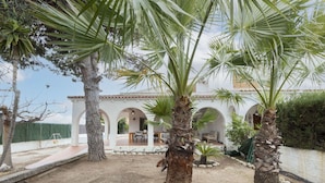 A courtyard with palm trees, a pool, and a building with arches. - Stunning private villa for 9 guests with WIFI, A/C, private pool, TV, patio and pets allowed (Deltebre)