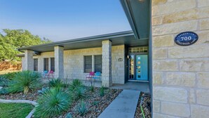 A stone building with a sign reading "700 Shangri-La Shadywood Lane." - Stylish Ranch House | Renovated Interior + Backyard Pool Oasis (Dripping Springs)