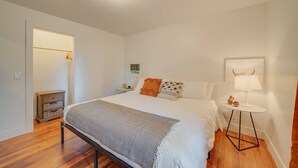 A bedroom with a bed, bedside tables, a lamp, and a small table with decorative items.