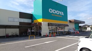 A supermarket with a large sign reading "ODOYA SUPERMARKET" and a covered entrance.