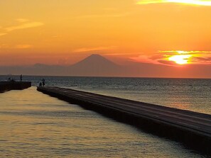A pier extending into calm waters with a sunset in the background. - Bettei Tateyama (Tateyama)