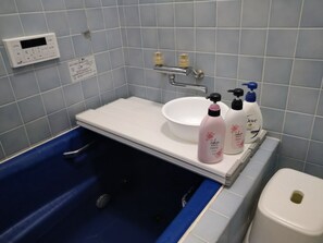 A bathroom with a bathtub, a sink, and toiletries. - Bettei Tateyama (Tateyama)