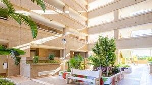 Un atrium à plusieurs niveaux, doté d’un jardin central, de bancs et d’un escalier.
