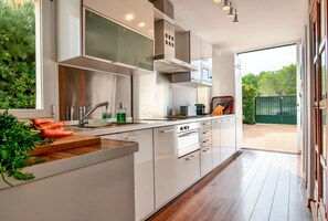 Enjoy cooking in this well-lit kitchen with a large island, oven, and stainless steel sink.
