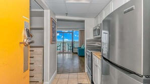 A modern kitchen with a stainless steel refrigerator, a microwave, and a wooden countertop. - Caravelle 1414 (Myrtle Beach)