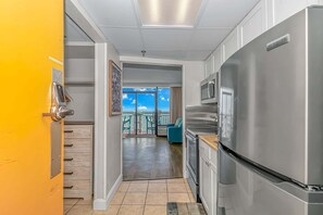A modern kitchen with a stainless steel refrigerator, a microwave, and a wooden countertop.