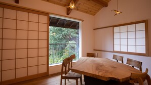 A traditional Japanese-style room with tatami flooring, a wooden dining table, and sliding shoji doors.