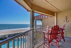 A balcony with a view of the beach and ocean, red Adirondack chairs, and a pool. - Top Floor Oceanfront & Sound Views, Pool, (North Topsail Beach)