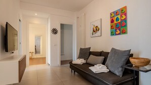 A modern living room with a sofa, a TV, and artwork on the wall. - Elisa apartment Sistine Chapel (Roma)
