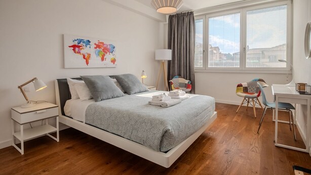 A modern bedroom with a bed, bedside table, lamp, and a desk with a chair. - Elisa apartment Sistine Chapel (Roma)
