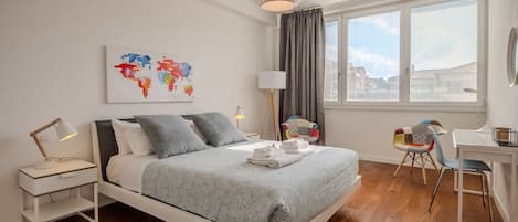 Une chambre à coucher moderne, avec un lit, une table de chevet, une lampe et un bureau avec une chaise.