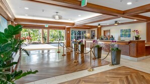 A hotel lobby with a reception desk, a waiting area, and a view of the outdoors. - Marriott's Waiohai Beach Club 2BR Islandview Villa (Koloa)