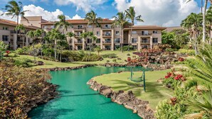A resort with multiple-story buildings, a central water feature, and lush landscaping. - Marriott's Waiohai Beach Club 2BR Islandview Villa (Koloa)