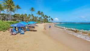A beach with sun loungers and umbrellas, palm trees, and the ocean. - Marriott's Waiohai Beach Club 2BR Islandview Villa (Koloa)