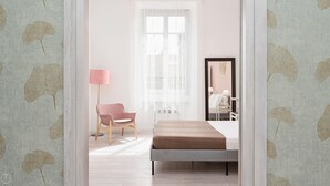 A bedroom with a bed, a chair, a floor lamp, and a mirror. - Italianway - Montello 10 - C (Milan)