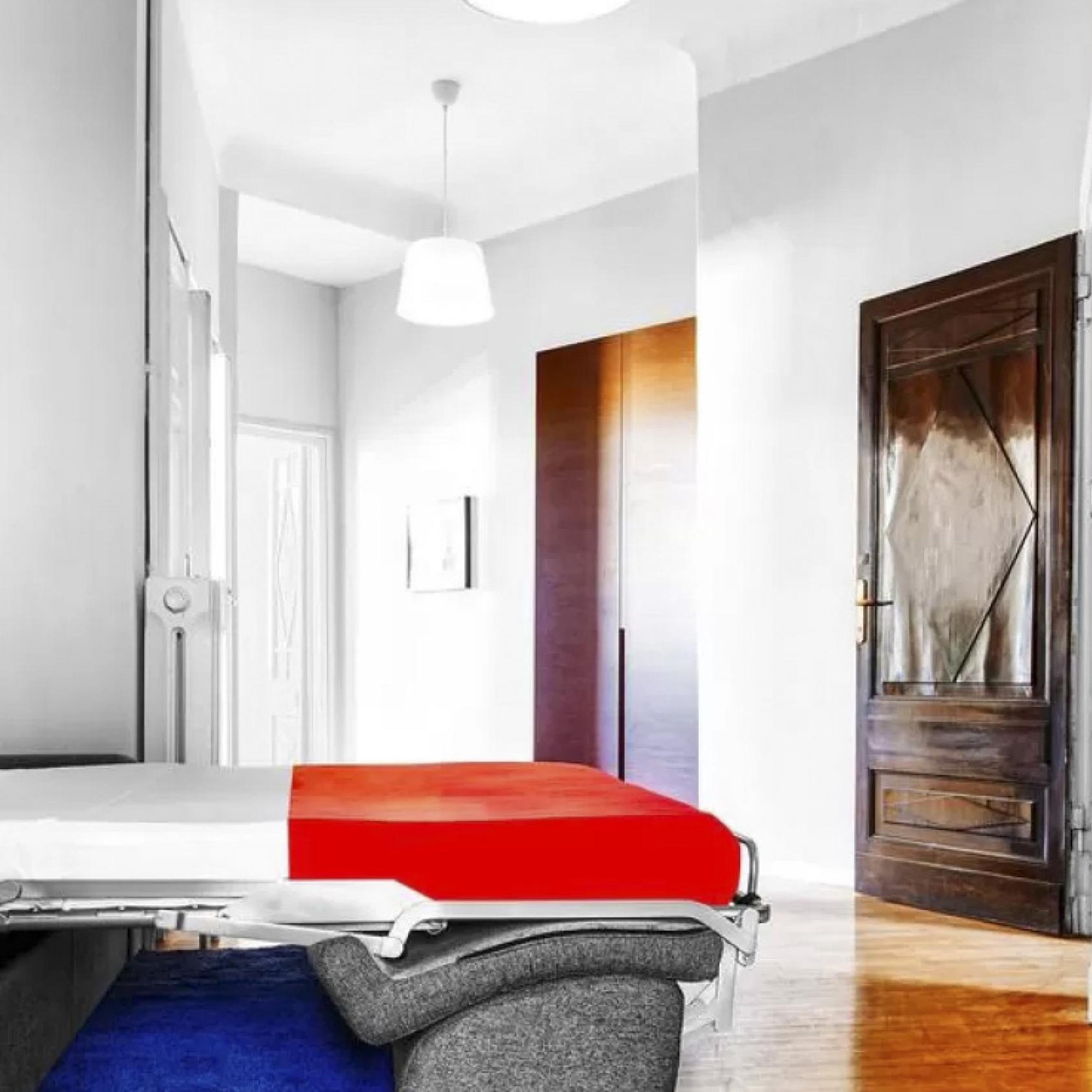 Une chambre d’hôtel moderne avec un lit, une porte en bois et un plafond blanc.