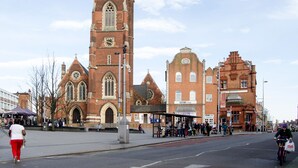 A historic building with a prominent tower and arched windows.