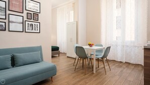 Un salon moderne comprenant un canapé, une table à manger avec des chaises et un meuble de rangement.