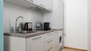 A compact kitchen with a sink, a coffee maker, and a built-in washing machine. - Italianway Collection - Cannobio 8 - Norma (Milan)