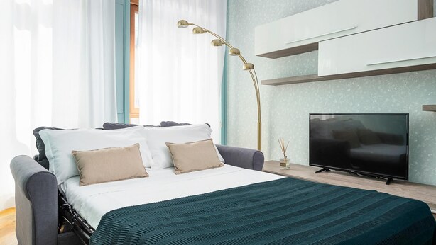 A modern bedroom with a bed, a TV, and a floor lamp. - Italianway Collection - Cannobio 8 - Norma (Milan)