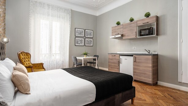 Une chambre moderne équipée d’un lit, d’un bureau et d’une kitchenette.