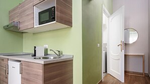 Una cucina compatta con forno a microonde, lavello e mobili moderni.