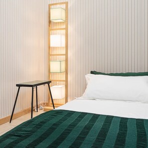 A neatly arranged hotel room with a bed, a small table, and a wall-mounted lamp. - Italianway Collection - Cannobio 8 - Butterfly (Milan)