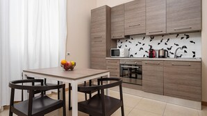 Een moderne keuken met houten kastjes, een magnetron, een waterkoker en een fruitschaal op het aanrecht.