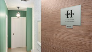 Een houten receptiebalie met een bord waarop staat 'Hemeras Boutique House' en 'Uw vakantie, onze passie'.