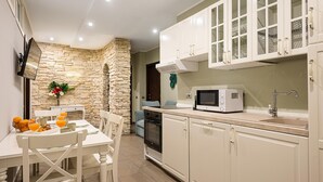 A modern kitchen with white cabinets, a microwave, and a dining area with a table set for breakfast.