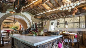 A rustic kitchen with a stone archway, wooden beams, and a variety of kitchen utensils and appliances. - Molino L Oppino 6 in Torrita di Siena (Torrita di Siena)