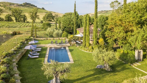 A pool surrounded by a well-maintained lawn, with lounge chairs and umbrellas. - Molino L Oppino 6 in Torrita di Siena (Torrita di Siena)