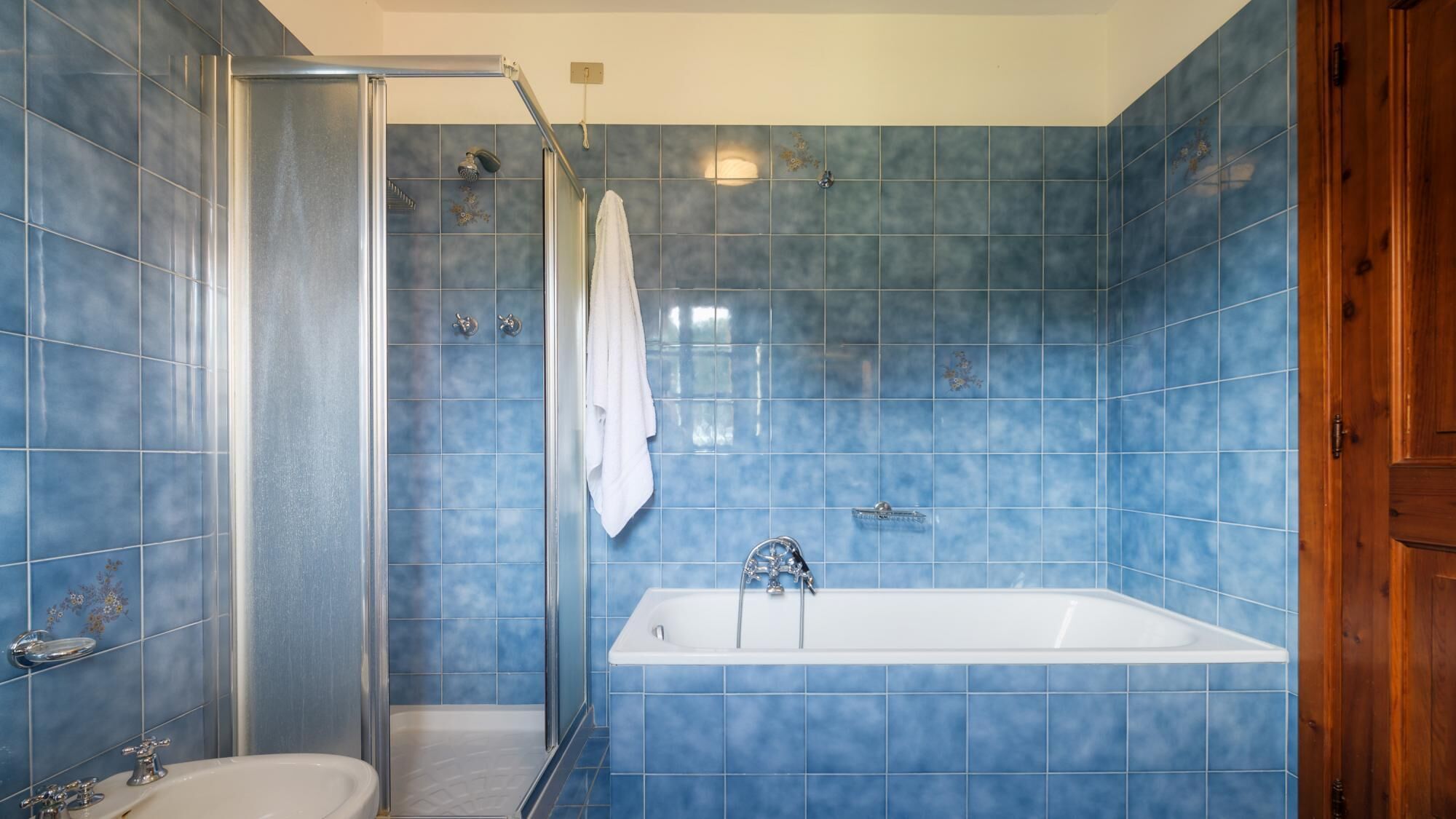 A bathroom with a shower, a bathtub, and a toilet.