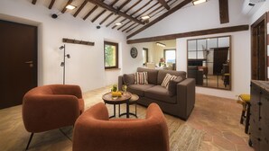 Una sala de estar con un sofá, dos sillones, una mesa de centro y una chimenea.
