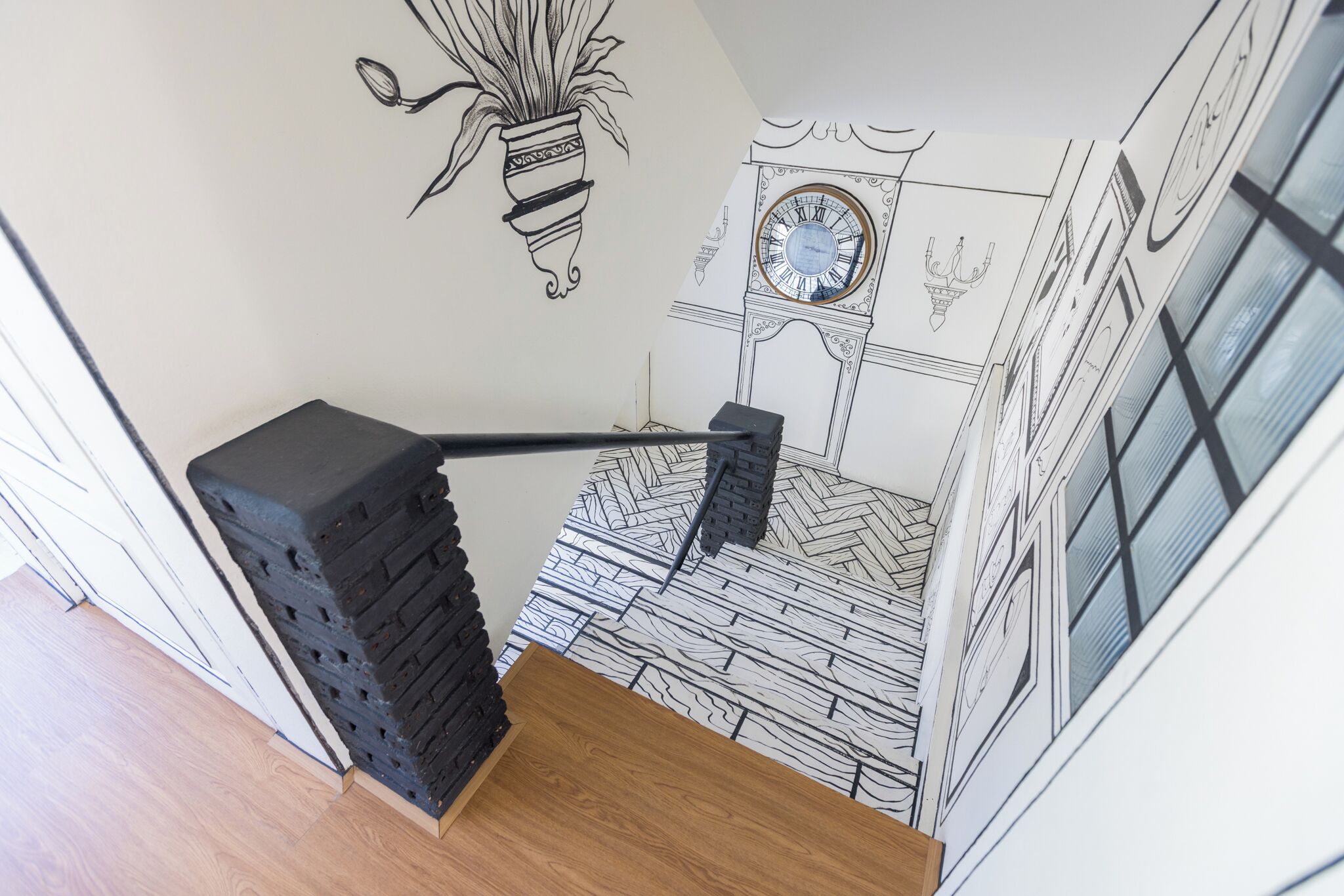 A staircase with a black handrail and a wooden step.