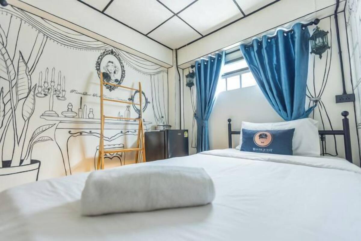 Une chambre à coucher avec un lit, un bureau, une échelle et une fenêtre avec des rideaux.