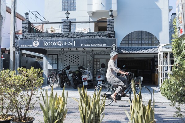 A building with a sign reading 'RoomQuest Premium homestay art.'