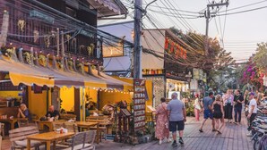 A street with outdoor seating, a variety of shops, and a crowd of people. - RoomQuest Chiang Mai Tha Phae (Chiang Mai)