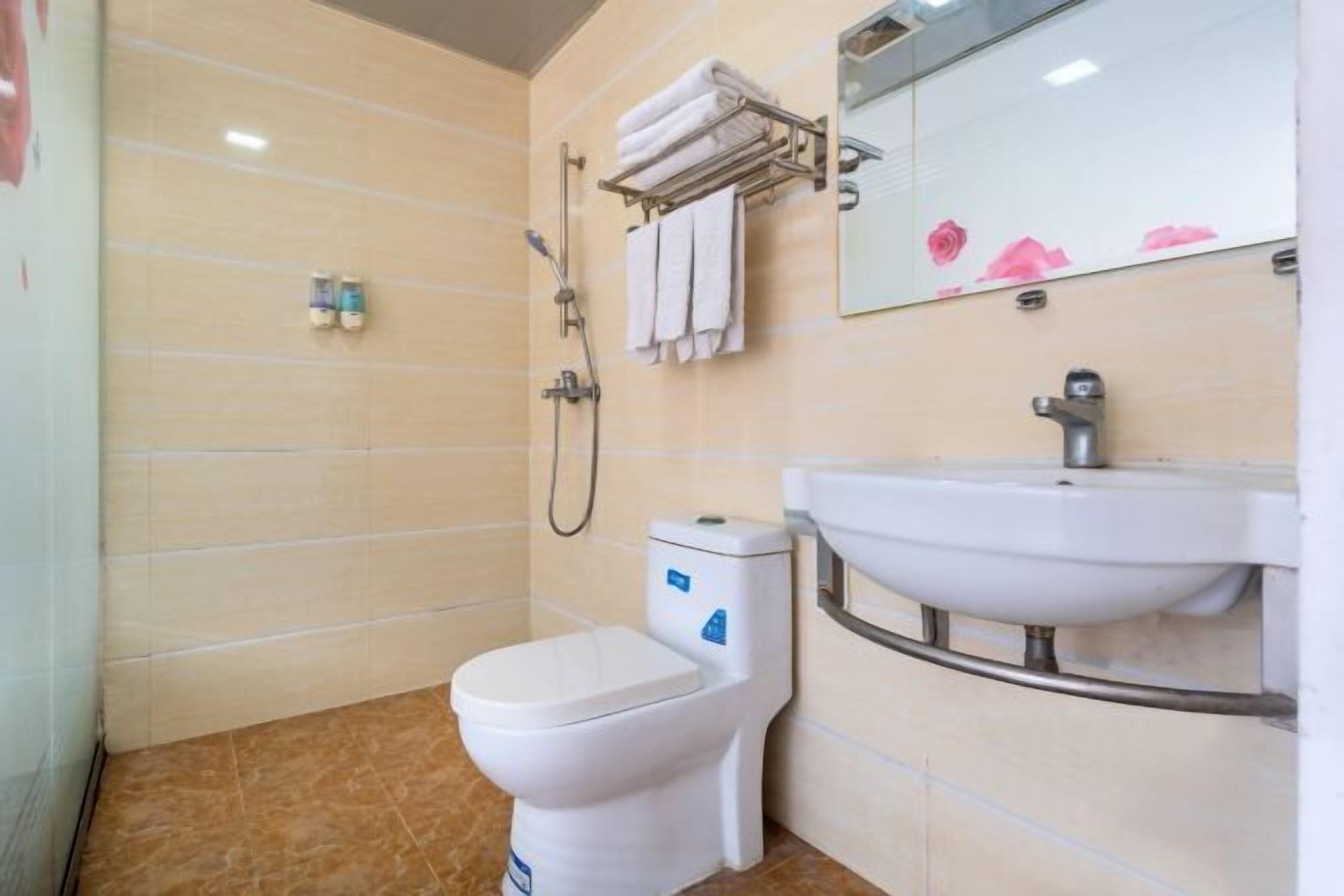 A bathroom with a toilet, sink, and shower.