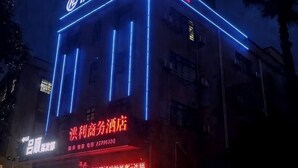 A building with illuminated blue vertical lines and a sign indicating a hotel. - Hongli Business Hotel (Foshan)
