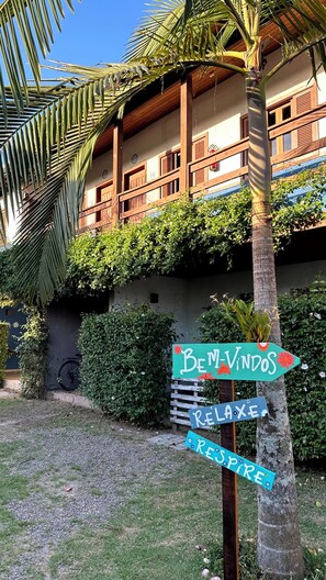 A sign with "Bem-Vindos Relaxe Respire" on a wooden post.